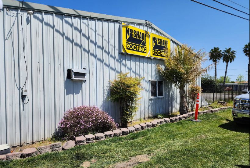 Residential home with new roof installed and company poster in yard